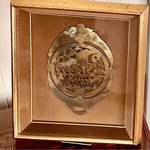 Antique horse brass in a shadow box frame.